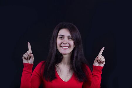 Pointing up Happy excited energetic woman .Portrait of cheering beautiful young women.Facial expression.の写真素材