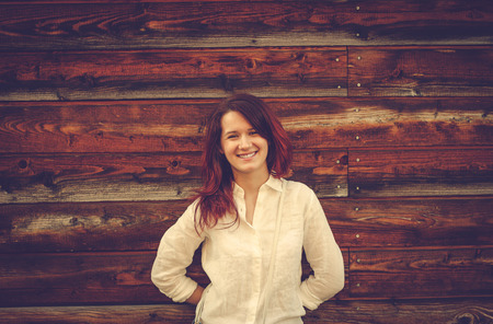 Young woman smiling over a wooden background.の写真素材