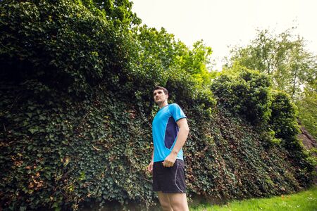 Healthy running runner man workout in a city park. Jogging male fitness model working out training  on park road.の写真素材