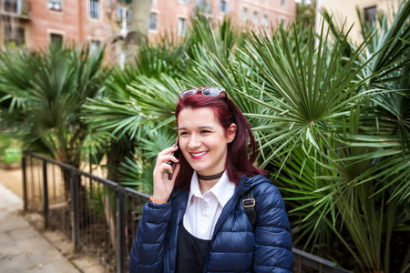 Happy smiling tourist woman talking on the phone outdoor in Barcelona.Traveling young woman talking on the phone.Technologyの写真素材