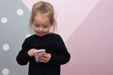 toddler little girl in the children room pointing at toy smartphone curiosityの写真素材