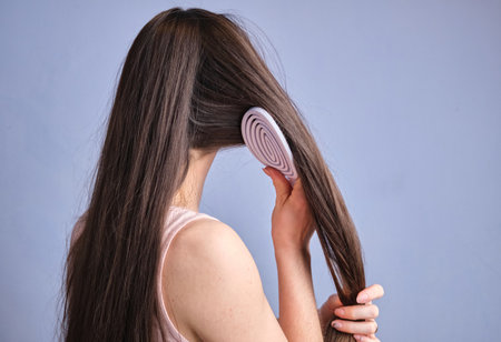 Young woman brush long healthy brunette hair morning beauty routine in bathroom hairstyle, haircare conceptの写真素材
