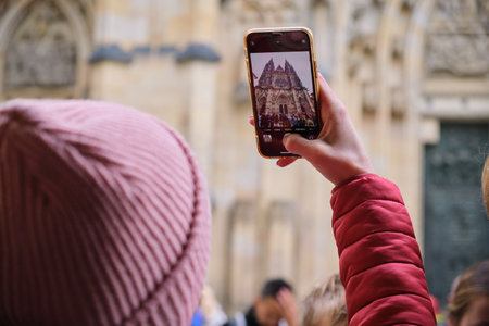 mobile phone photo Tourist woman traveling St. Vitus Cathedral takes a photo in Pragueの写真素材