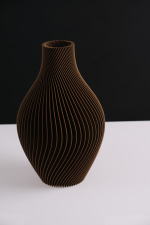 creative 3D technology printed brown vase home decor with a flowing geometric texture Decorative Vase For Flowers made from recycled plastic isolated black backgroundの写真素材