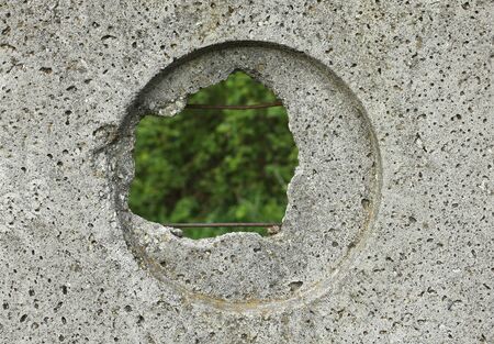 Hole in a cement fenceの写真素材