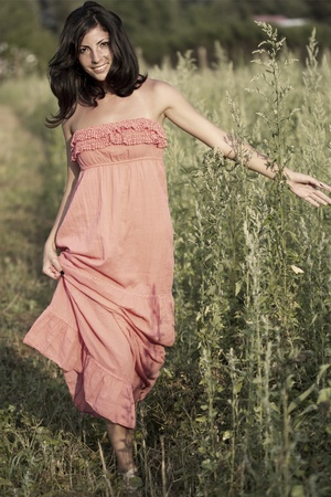 Countryside young woman walking in a grass fieldの写真素材