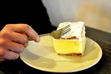 Closeup on Slovenian traditional local Gibanica -hand cutting with a fork in a restaurant in Bled.