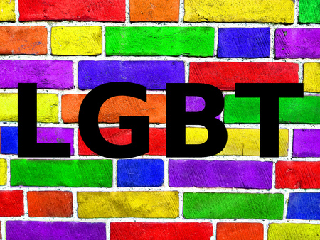 Rainbow flag on a brick wall, old brick wall texture background, gay pride, free love, human rights concept. Writing LGBT.の写真素材