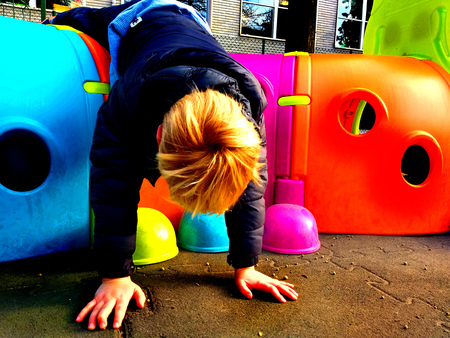 Little child playing otudoor in a playground with a colourful toy, fun and play concept