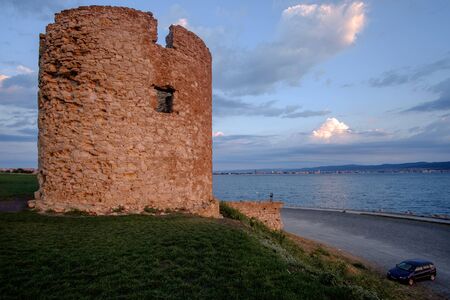 Sunrise and ruins of the castle tower on the Black Sea coast in the Ancient City of Nesebar