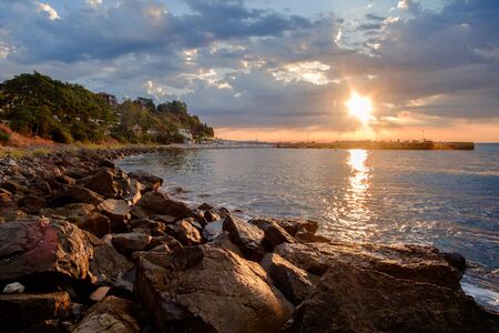 Golden sunrise over the Nesebar bay and beach with big rocks on it. Bulgariaの写真素材