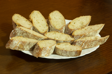 dish full of bread slices over a wooden backgroundの写真素材