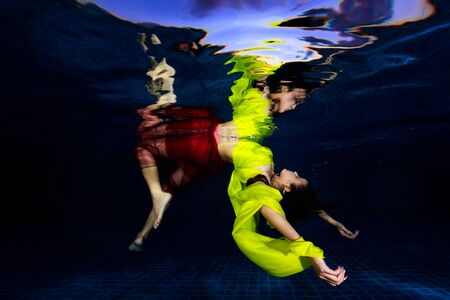 young female dancing underwater, enjoying summer vacation in blue transparent water, dive to swimming pool, freedomのeditorial素材