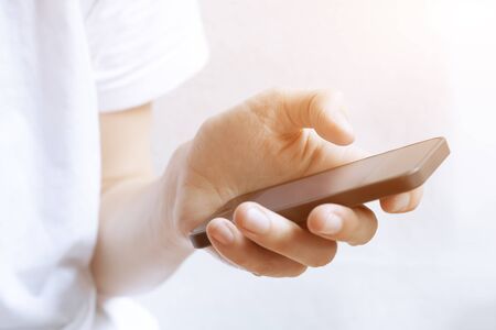 Using smartphone with one hand in bright interior at sunset