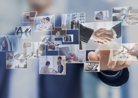 Businessman touching a photo on a digital screen interface, abstract images of business situationsの写真素材