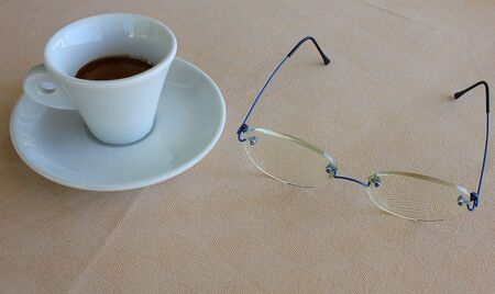 a cup of coffee and a pair of glasses,の写真素材