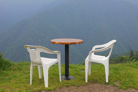 chairs and table in a meadow in front of the mountainの写真素材