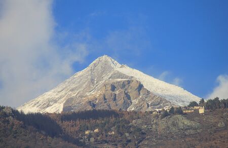 the forest and some houses in front of the mountainの写真素材