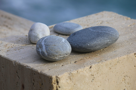 some stones on the wall in front of the seaの写真素材