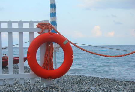 a lifebuoy on the palisade in front of the seaの写真素材