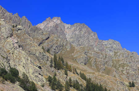 a mountain panorama with rocks and trees in Italyの写真素材