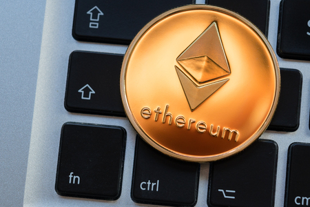 Cryptocurrency Ethereum coin on computer laptop keyboard. Finance, investment and money conceptの写真素材