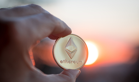 Hand holding Ethereum at sunset. Selective focus