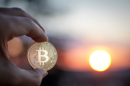 Hand holding Bitcoin at sunset. Selective focusの写真素材