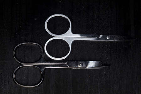 Tiny scissors for embroidery on a black wooden surfaceの写真素材