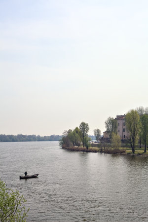 Boat with a fisherman on a lake on a sunny dayの写真素材