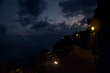 Panoramic walk by the sea lit by street lights at duskの写真素材