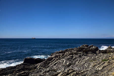 Bare cliff by the sea on a sunny clear day