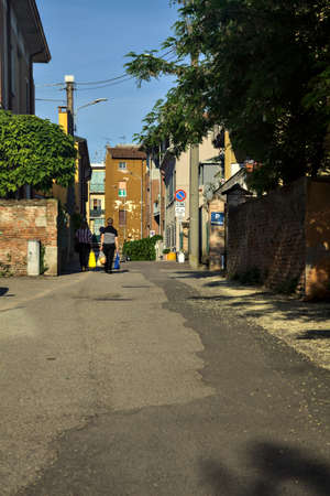 People with shopping bags walking on a street at sunsetの写真素材