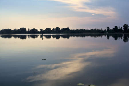 Lake at sunset with the opposite shore in the distance