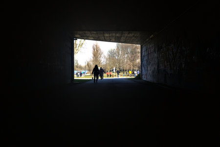Passageway under a bridge with people strolling on a sunny dayの写真素材