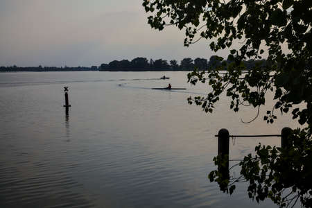 Kayak on a lake at sunset seen from the distance