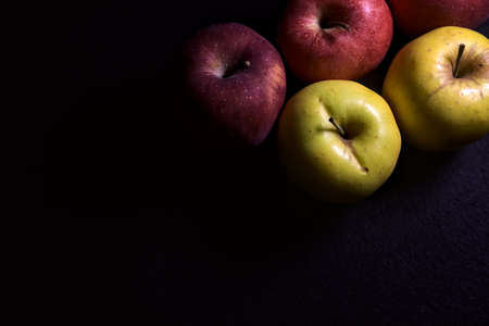 Red and yellow apples on a black backgroundの写真素材