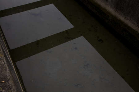 Concrete aqueduct next to a bridge on a cloudy day in winter