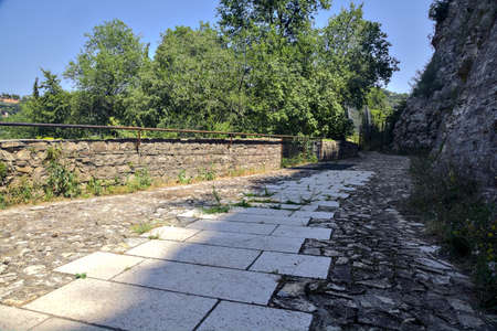 Paved path on a balcony next to a grove by the side of a cliffの写真素材