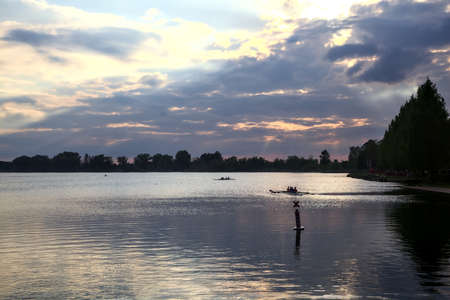 Canoe on a lake seen from the distance at sunset