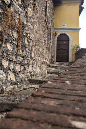 Stone staircase next to a wall that leads to a door of a houseの写真素材