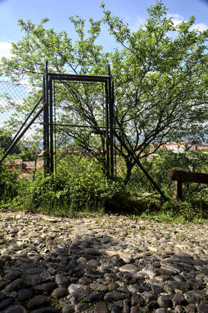 Metallic gate by the edge of a paved road on a hillの写真素材