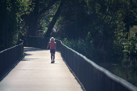 Woman walking on a bridge in a park on a sunny day