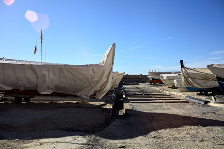 Ground boats on a beach on a sunny day by the seasideの写真素材