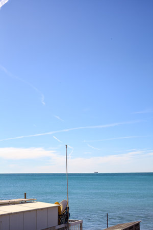 Sea stretching to the horizon on a sunny day framed by a building by the beachの写真素材