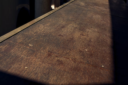 Wooden plank with a metallic border lit by the sun seen up closeの写真素材
