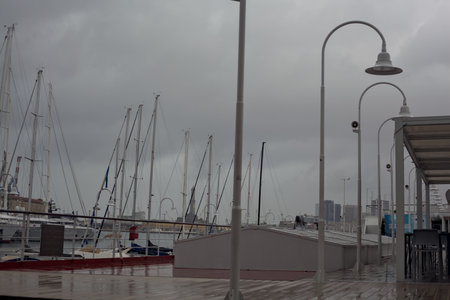 Harbor seen from the terrace of the Acquario di Genova and the Lanterna of Genova in the distance on a rainy dayの写真素材