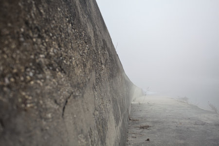 Concrete embankment of a diversionary channel on a foggy day in the Italian countrysideの写真素材