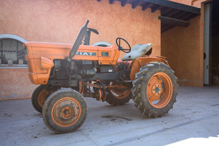 Mantua, Italy - May 2024 - Old Fiat tractor in a yard of a country house on a sunny day