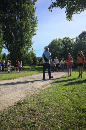 Mantua, Italy - May 2024 - People and children strolling in a park during a rural fair